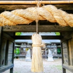 建部神社の門に掛かる注連縄。神域の奥へ、祈りの層が重なっていく。